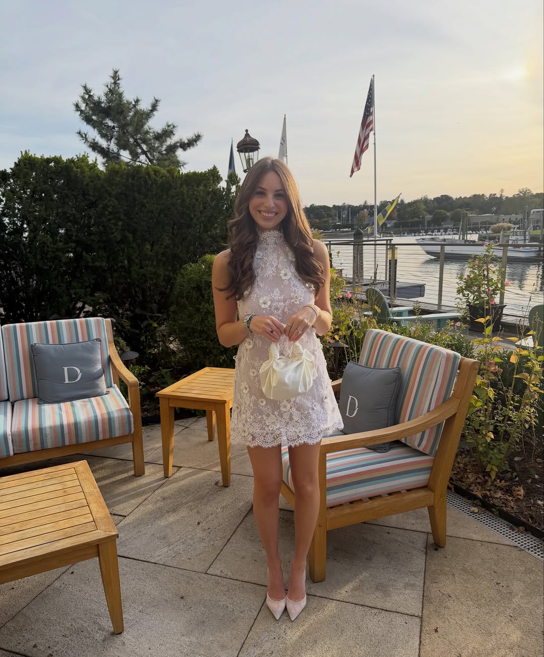 White sleeveless mini dress with a high mock neck, featuring an all-over floral lace overlay and scalloped hem.