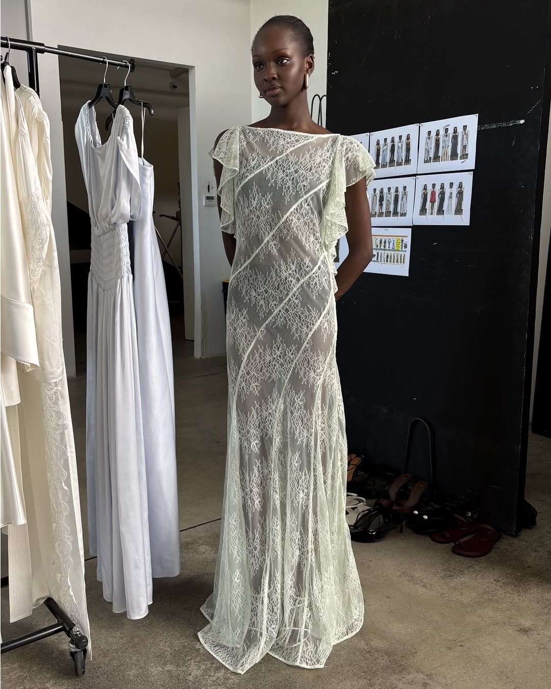 Model in a long-sleeved sheer white lace dress with diagonal paneling.