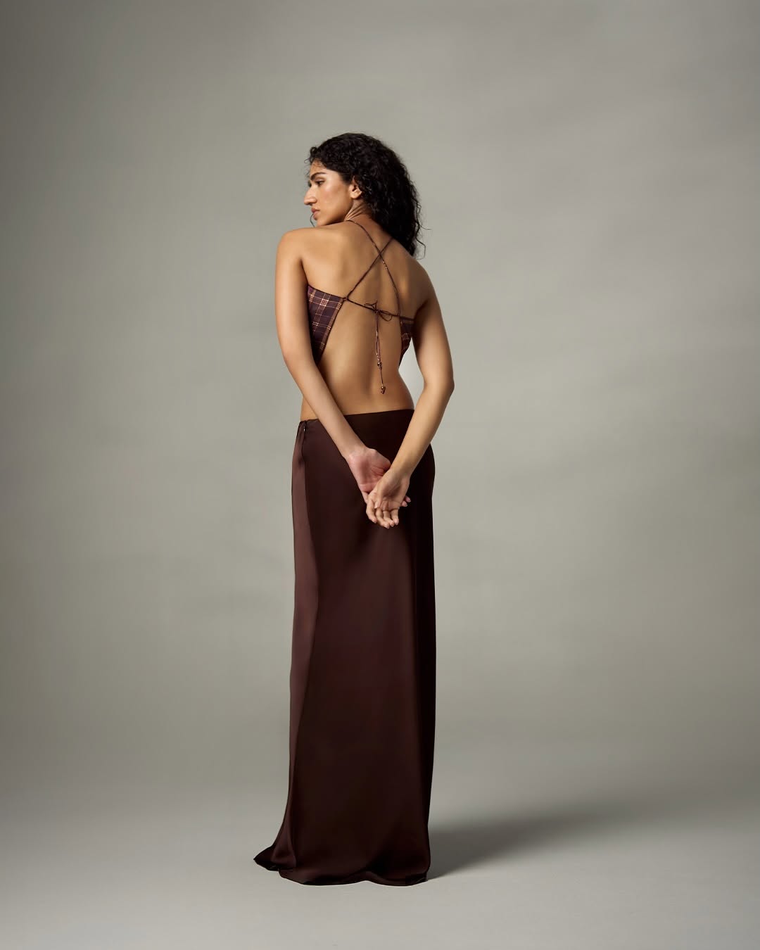 A floor-length, dark chocolate brown satin maxi skirt with a smooth texture and straight silhouette.