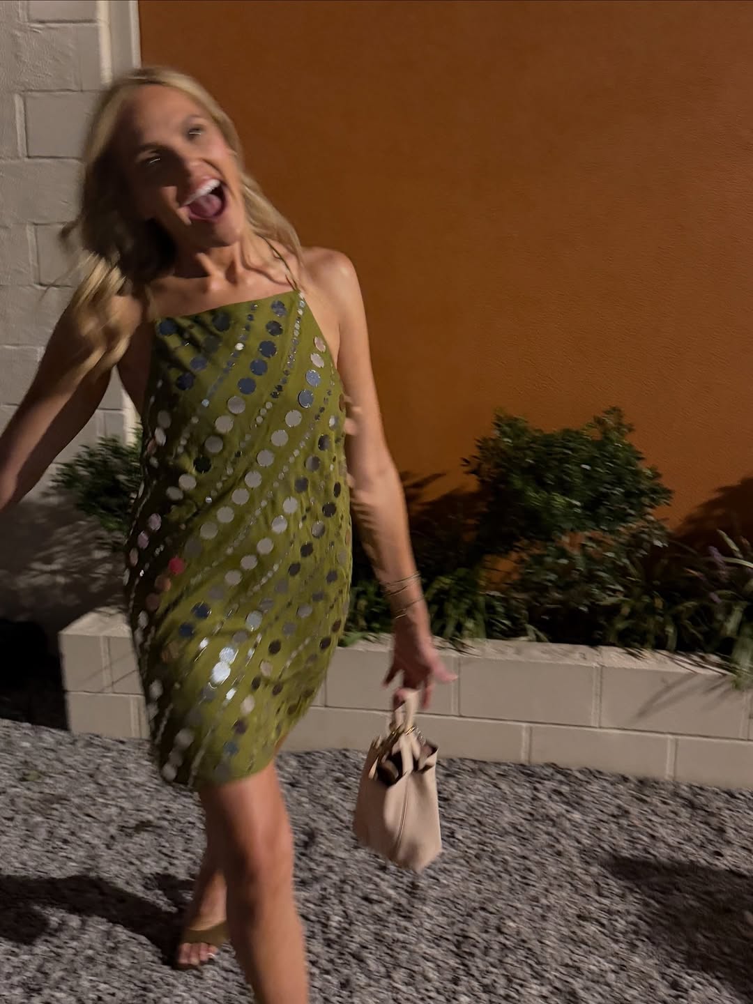 Olive green mini dress with thin spaghetti straps, featuring a pattern of large, reflective silver sequin dots arranged in diagonal lines.