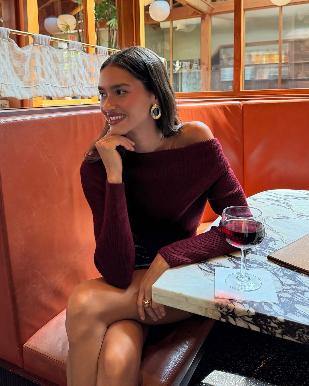 Burgundy off-the-shoulder ribbed knit long-sleeve sweater.