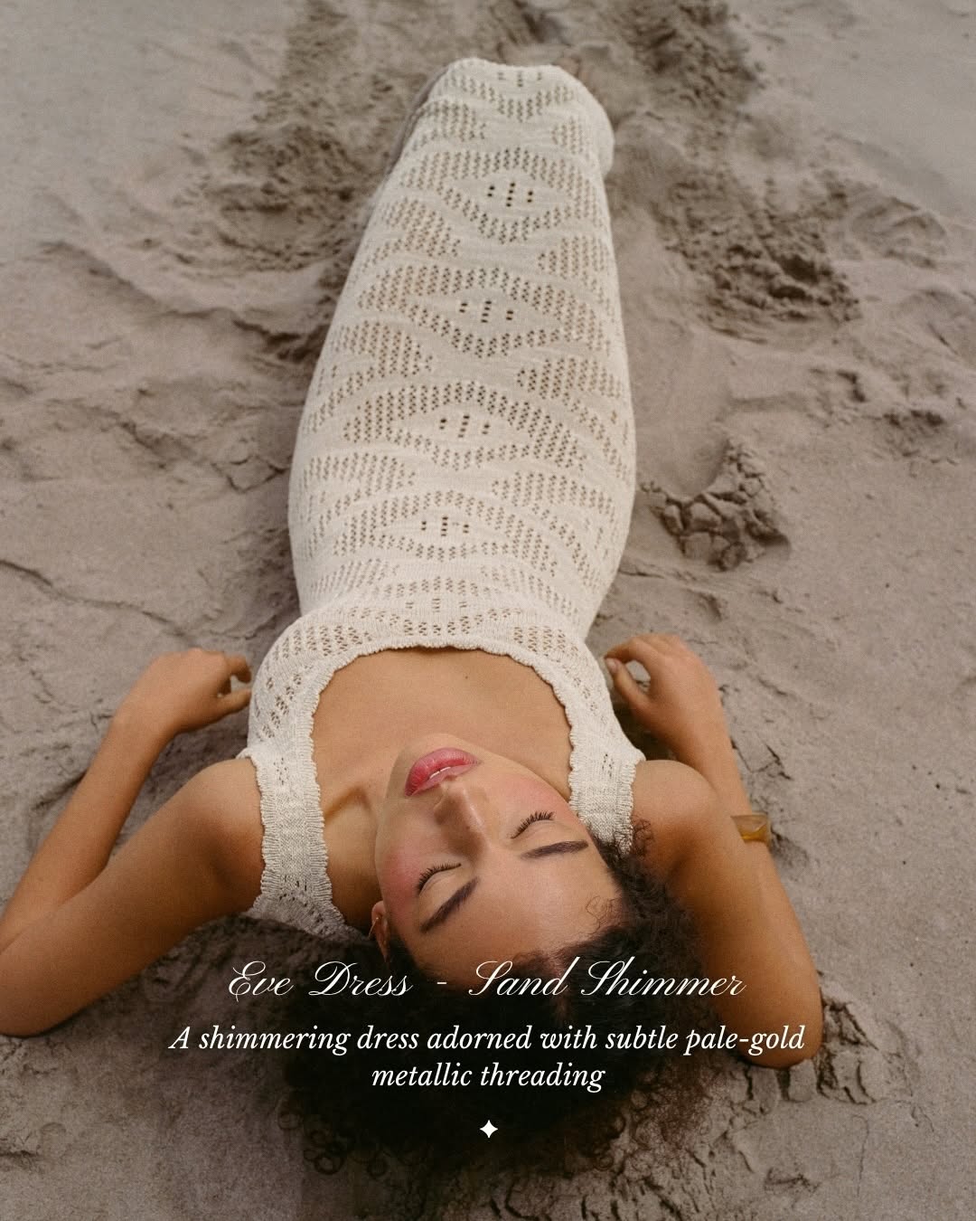 Model lying on sand wearing a cream pointelle knit maxi dress.
